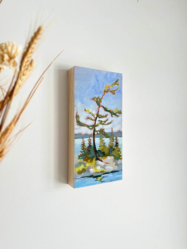 painting of windswept pine growing near a blue lake