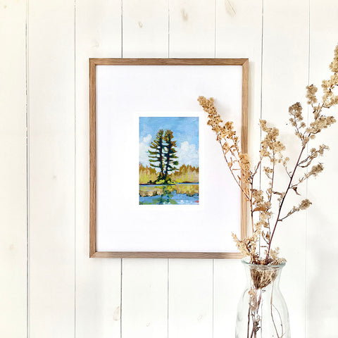 a lake print of two pine trees growing beside a calm Canadian lake