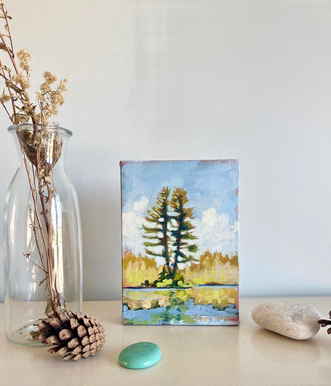 Canadian landscape art painting of tall pine trees near a calm blue lake 